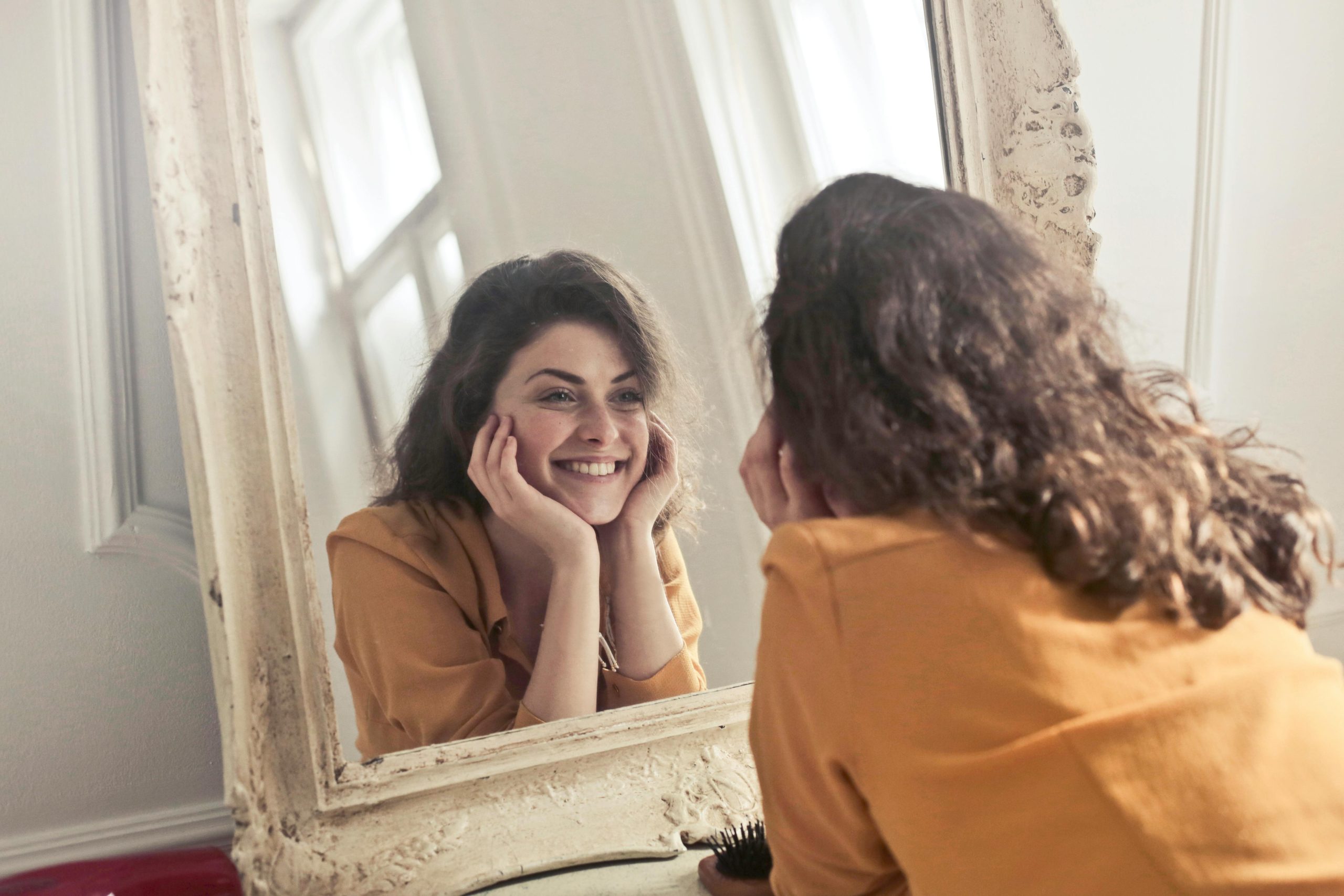 femme-souriante-se-regarde-dans-un-grand-miroir